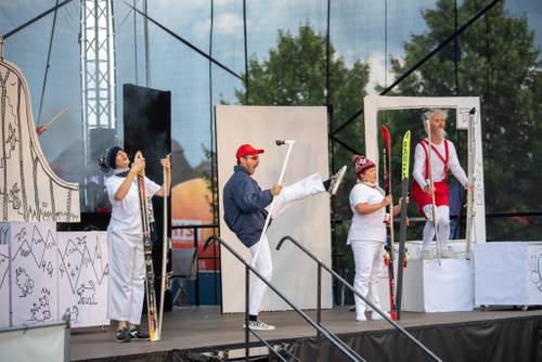 Aktor przebrany za Koziołka Matołka i inne postaci na scenie podczas wystepu. Aktorzy mają narty.