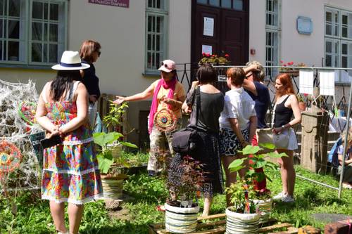 Uczestnicy i organizatorzy podczas pikniku przed budynkiem biblioteki.