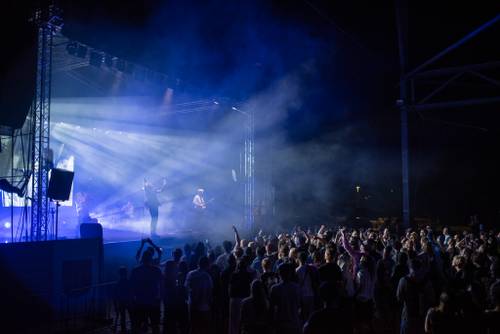 Koncert Szczyla. Szeroki kadr na scenę i publiczność. Publiczność pod sceną bawi się podczas koncertu.