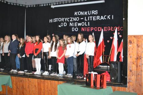 Młodzież podczas występu na scenie w auli.