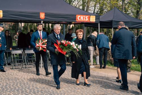 Oficjele składają kwiaty podczas obchodów upamiętniających zbrodnię katyńską w obstawie żołnierzy.