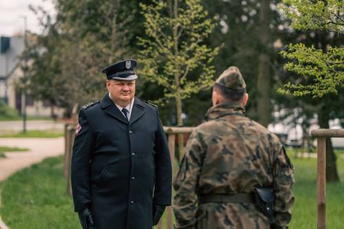 Przekazanie prowadzenia uroczystości podczas obchodów upamiętniających zbrodnię katyńską w obstawie żołnierzy.