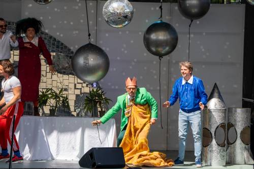 Kolorowo ubrani aktorzy na scenie.