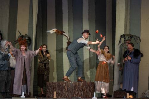 Aktor z ogonem lisa stoi na pniu.