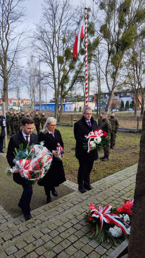 Goście uroczystości składają kwiaty pod pomnikiem przy ul. Powstańców Warszawy.
