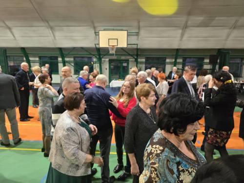Uczestnicy balu tańczą w parach.