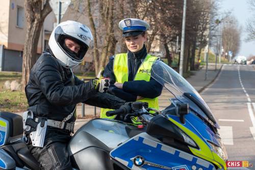 Policjanci podczas zabezpieczania imprezy. Mężczyzna na motocyklu.