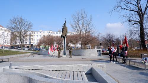 Żołnierze oraz poczty sztandarowe pod pomnikiem Nike na Placu Jana Pawła II w Pruszczu Gdańskim.