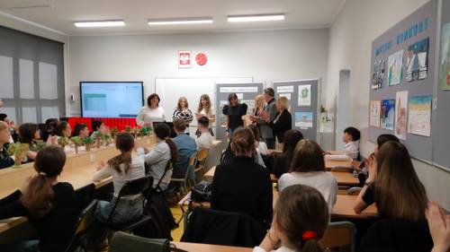 Uczniowie- uczestnicy odbierają dyplomy. Widok z tyłu sali.