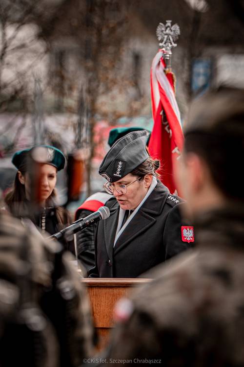 Kobieta w mundurze przemawia.