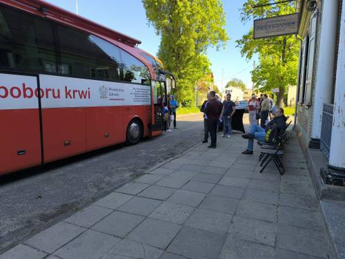 Uczestnicy podczas oczekiwania na wejście do punktu. Z lewej strony widać autobus.