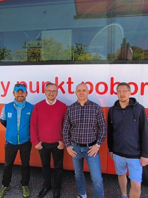 Organizatorzy i partnerzy stoją przed autobusem.
