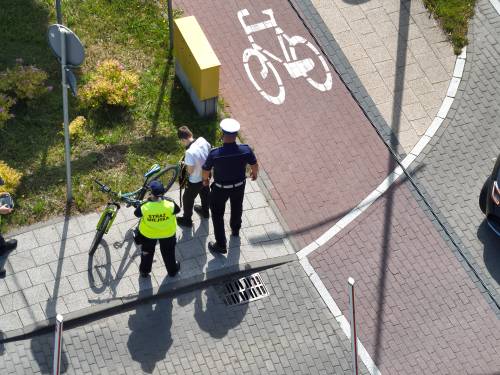Chłopiec - rowerzysta w towarzystwie funkcjonariuszy