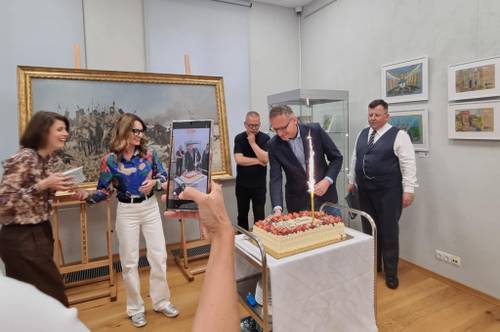 Tort z okazji urodzin Domu Wiedemanna, obok stoi burmistrz Janusz Wróbel i inne osoby
