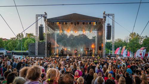 Scena muzyczna na Faktorii, na scenie Oskar Cyms z muzykami, przed sceną licznie zgromadzona publiczność