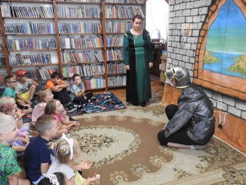 Dzieci uczestniczą w przedstawieniu. W tle scenografia przedstawiająca zamek.