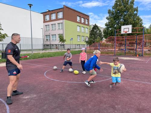 Dzieci pod okiem trenera grają w rugby