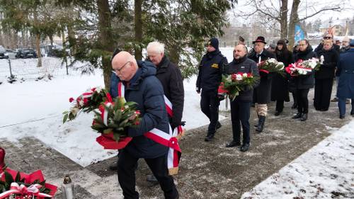 Osoby składające wieniec pod pomnikiem