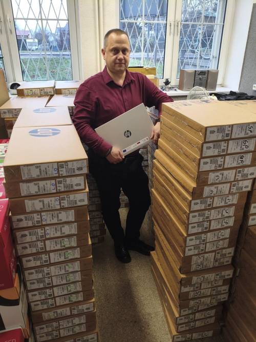 Mężczyzna trzyma nowy laptop marki HP.