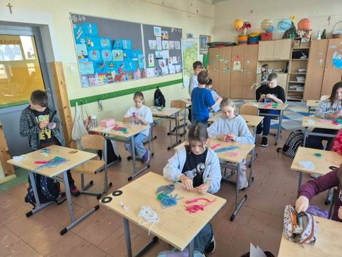 Uczniowie wykonują skrzaty z włóczki