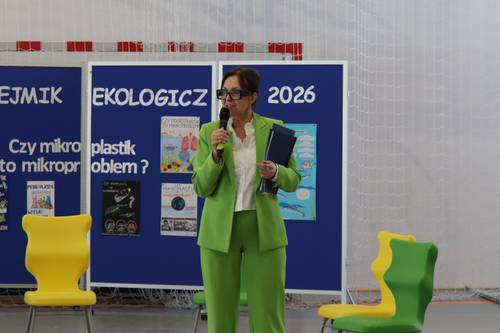 Dyrektor Szkoły Podstawowej nr 2 stoi przed tablicą z napisem Sejmik Ekologiczny 2026 i mówi do mkrofonu