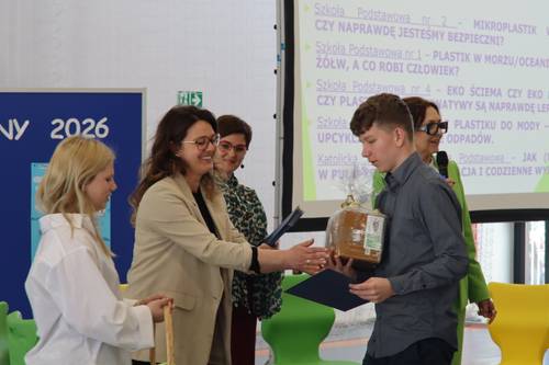 Nauczycielka wręcza uczniowi nagrodę