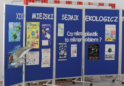 Tablica z napisem XIX Miejski Sejmik Ekologiczny i kolorowymi plakatami