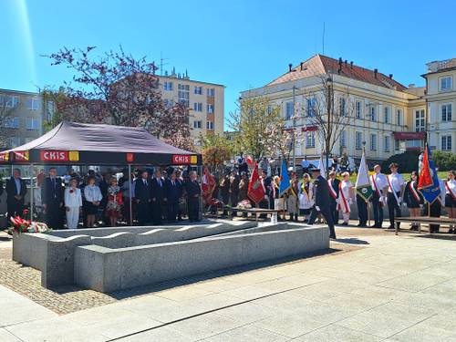 Na placu Jana Pawła II stoją samorządowcy, zaproszeni goście i poczty sztandarowe