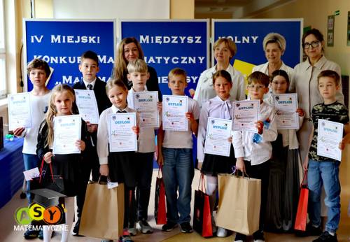 Grupa dzieci z dyplomami i nagrodami wraz nauczycielkami i dyrektor szkoły