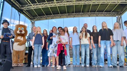 Grupa młodzieży z dorosłymi na scenie