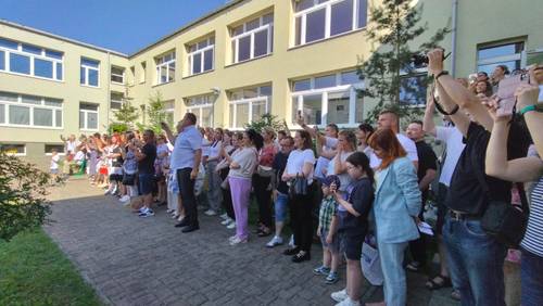 Grupa rodziców nagrywająca telefonami uczniów