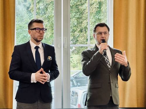 Zbliżenie na dwóch mężczyzn, jeden z nich trzyma w ręku mikrofon