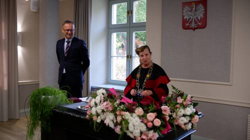 Burmistrz Pruszcza Gdańskiego i kierownik USC stojąca za biurkiem z kwiatami