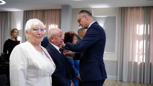 Burmistrz Pruszcza przypina medal do klapy marynarki starszego pana