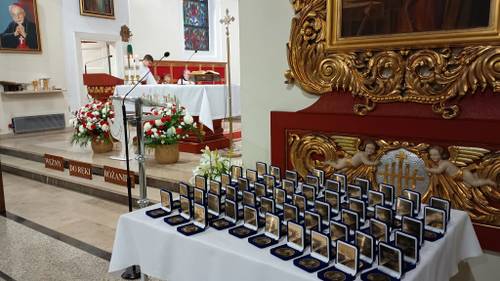 Zbliżenie na stół z medalami w granatowych pudełkach