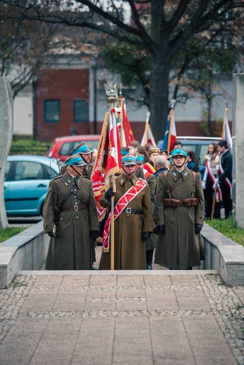Żołnierze w strojach galowych ze sztandarami