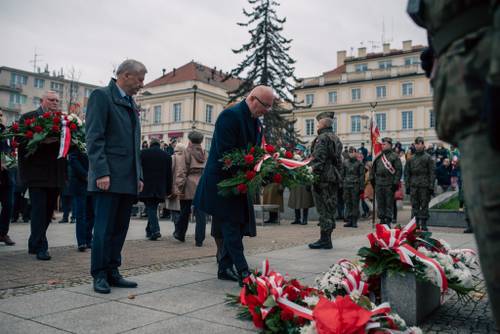 Kolejni uczestnicy składający kwiaty pod pomnikiem.
