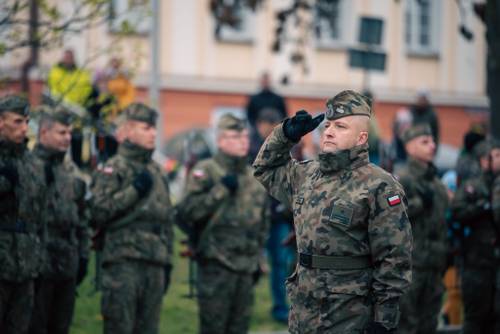 Salutujący żołnierz, w tle rząd żołnierzy.